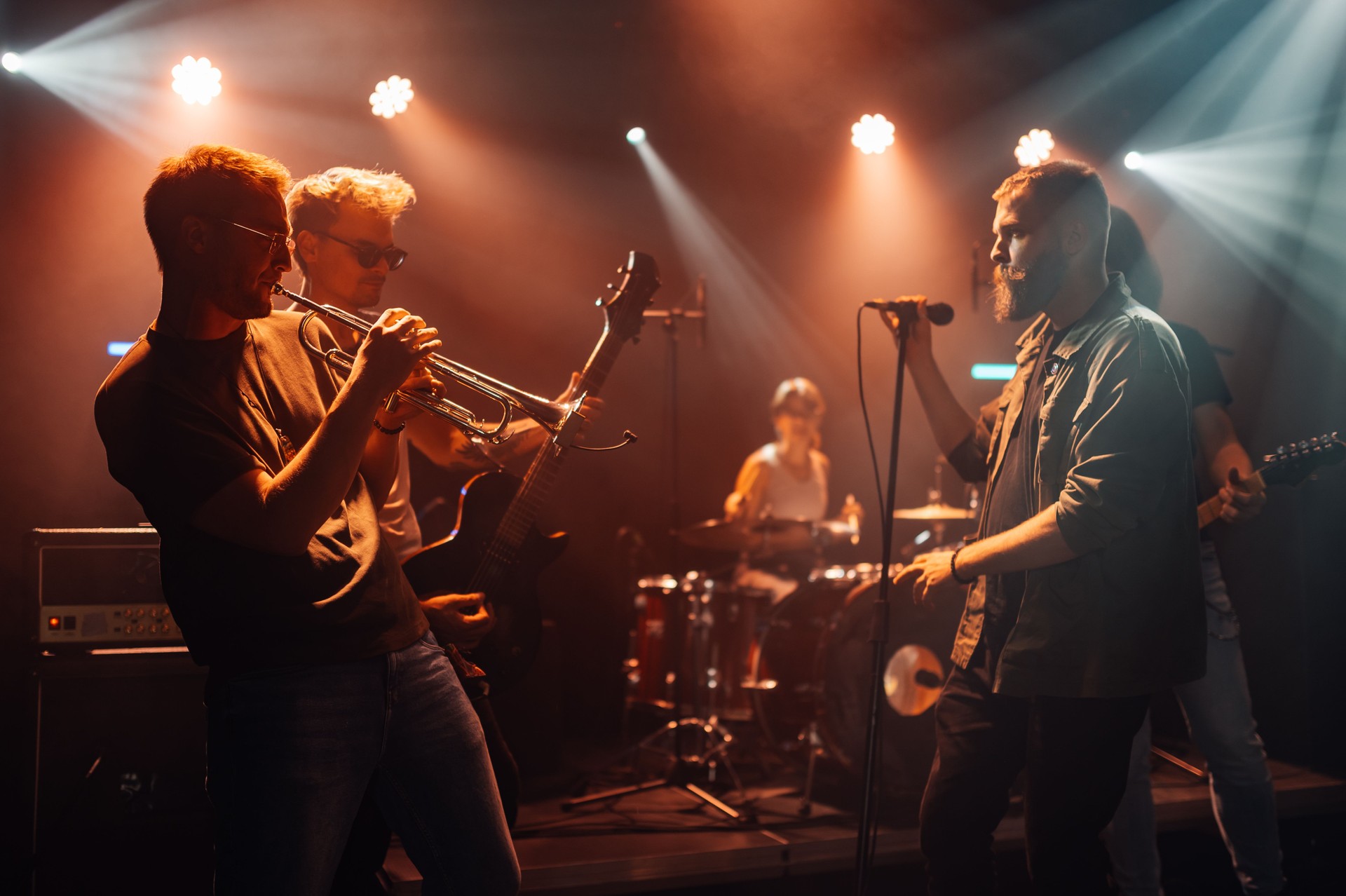 Musicians performing live on stage with instruments
