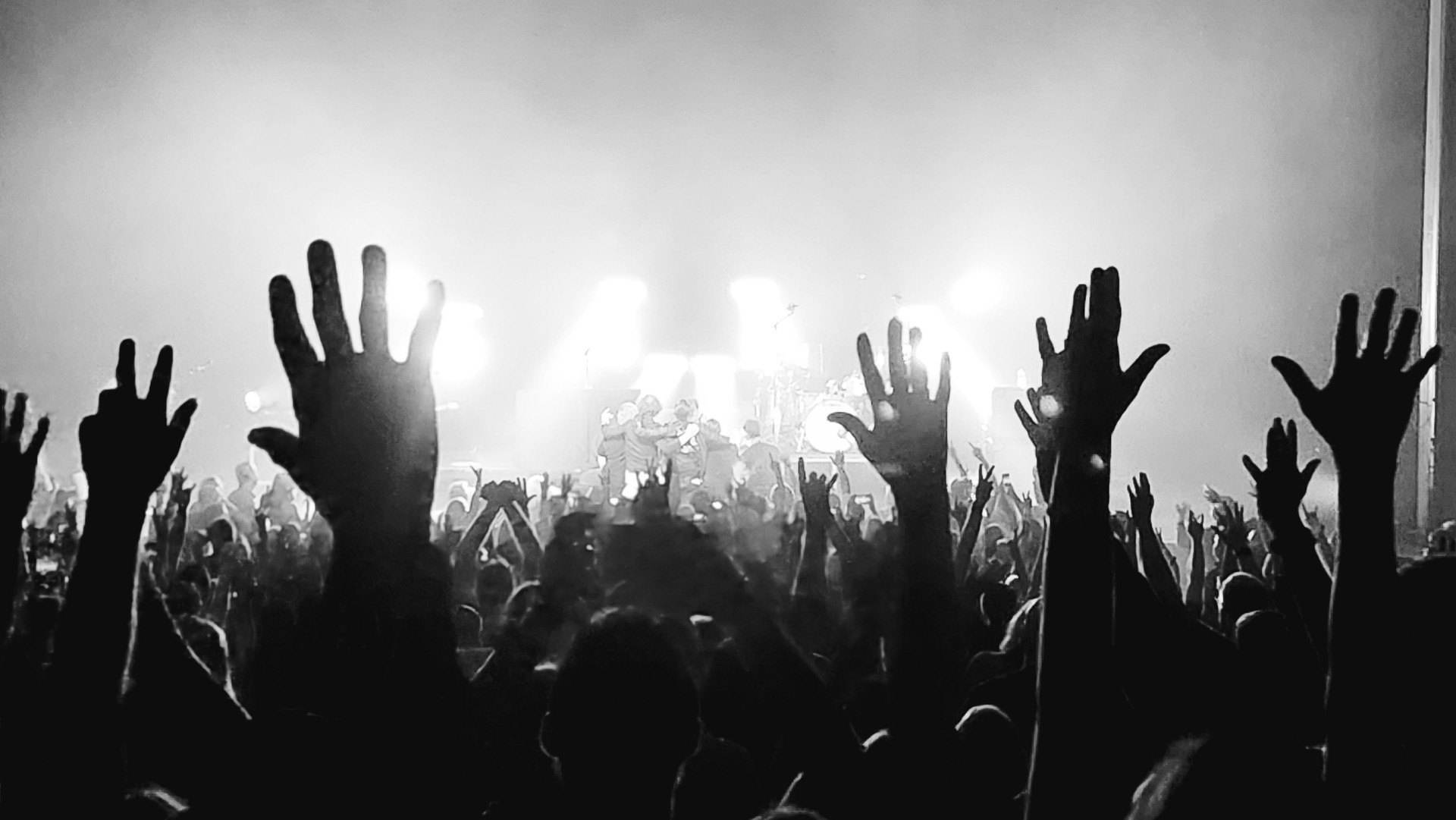 Hands in the air at concert from back of room - black and white in Central Florida